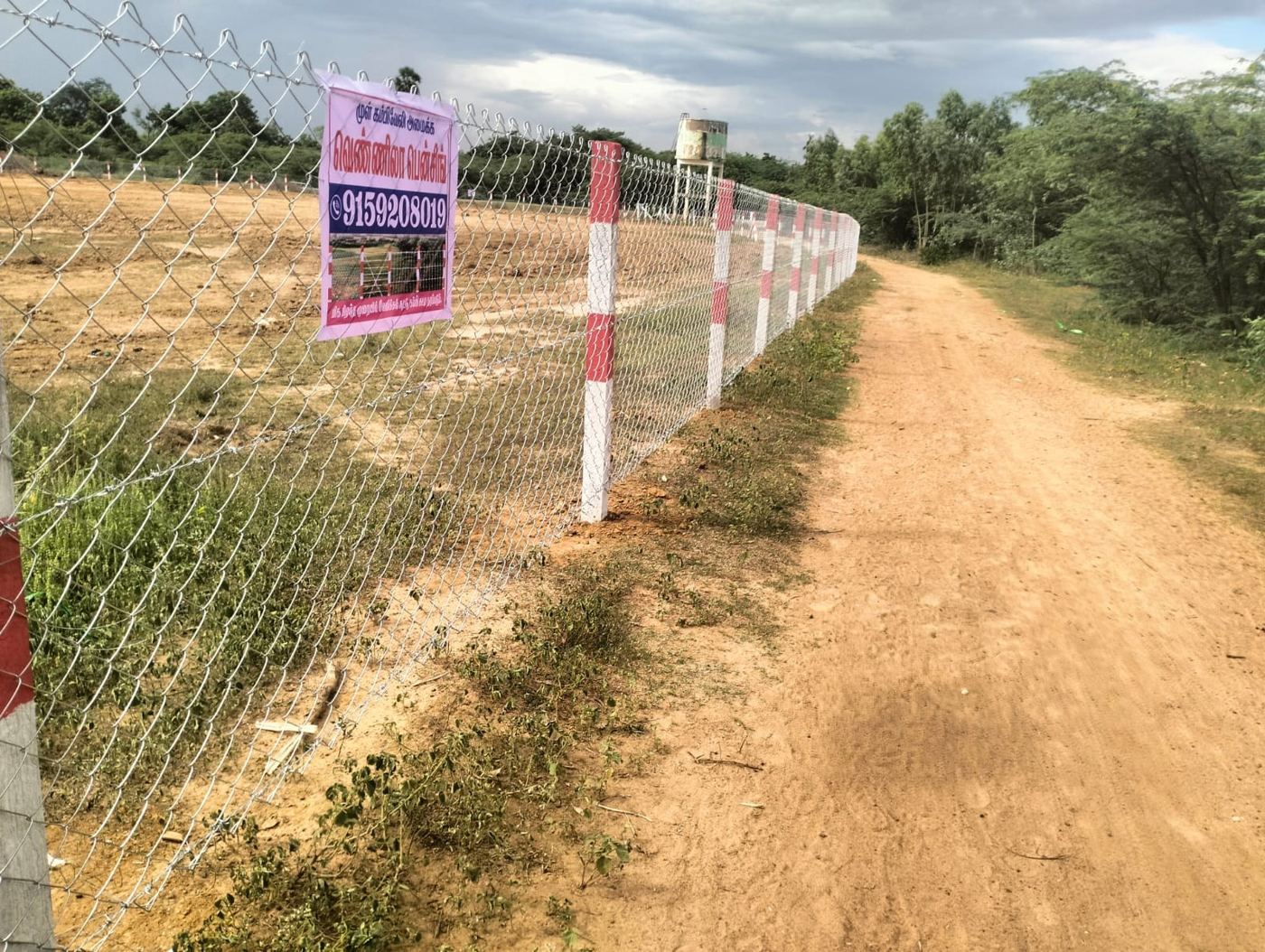 Chain-link fence line beside a farm access road
