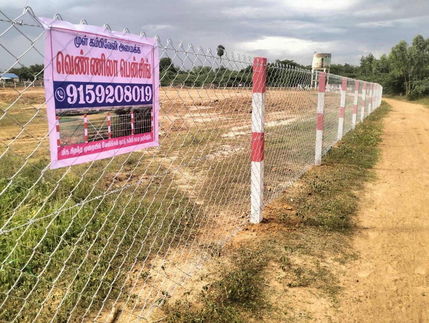 Freshly installed chain-link fence with red and white posts